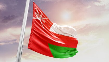 Waving Flag of Oman in Blue Sky. The symbol of the state on wavy cotton fabric.