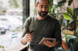 © Westend61 - Bearded man holding credit card using tablet PC in cafe
