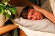 © Westend61 - Man covering ears lying down on bed at home
