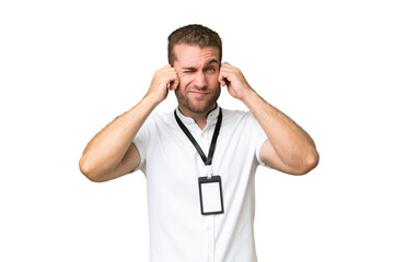 Wall Mural - Young caucasian man with ID card isolated on green chroma background frustrated and covering ears