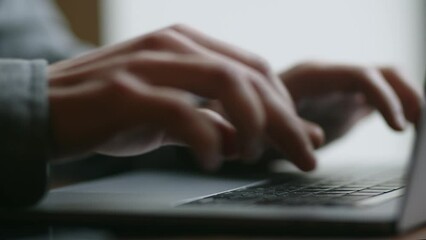 Male hands are typing on a keyboard. Remote work on a laptop. Cropped view of a man working with computer. Programming process