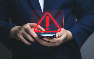 Wall Mural - Businessman using smartphone with warning triangle showing a system error. Concepts of system maintenance, security, anti-virus, and anti-hacking access to critical data.