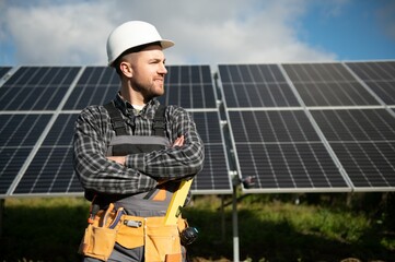 Wall Mural - Male worker in uniform outdoors with solar batteries at sunny day.