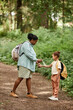© Seventyfour - Vertical side view portrait of mother and daughter travelling in nature together and using mosquito repellent