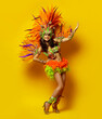 Beautiful brazilian woman in brazilian carnival costume on yellow background
