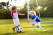 © famveldman - Kids play football. Child at soccer field.