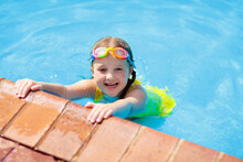 Child With Goggles In Swimming Pool. Kids Swim.
