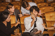 Concept Etiquette in the cinema Do not talk on the phone to disturb others : Selfish men talking on the phone among moviegoers annoy those around them who resent their bad behavior.