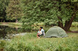 © Seventyfour - Wide angle view at mother and daughter camping together outdoors and fishing, copy space