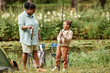 © Seventyfour - Full length portrait of happy mother and daughter fishing together during camping in nature