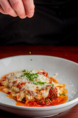 Wall Mural - Eggplant parmigiana Traditional Italian comfort dish. Sliced eggplant covered in breadcrumbs Lightly fried, topped with homemade marinara, melted mozzarella, parmigiana and Italian parsley. 