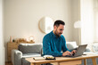 © bnenin - Busy male employee working over the laptop, sitting at the home office.