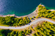 The road near turquoise lake. Aerial landscape. The road by the lake in Switzerland. Summer landscape from the air. Forest and road with curves.