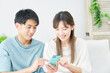 © siro46 - 家でスマホを使うカップル