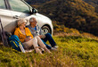 © Zoran Zeremski - Senior couple sitting against the car, resting after hiking in countryside.