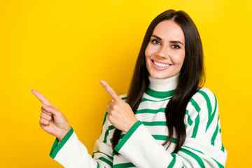 Wall Mural - Photo of positive adorable woman wear striped sweater pointing two fingers empty space isolated yellow color background