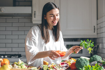 Attractive young woman with vegetables and fruits in the kitchen.