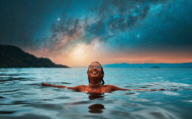 beautiful young woman submerged in water up to her neck happy smiling relaxed with open arms with milky way in the background