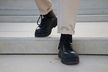 Detail Of Black Boots Of Man Walking Down Stairs.