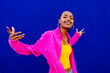 © VISTA by Westend61 - Happy young woman having fun dancing in front of blue wall