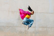 © VISTA by Westend61 - Young woman hip hop dancing in front of wall