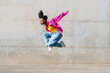 © VISTA by Westend61 - Dancer jumping in front of wall on sunny day