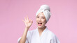 © Jirawatfoto - Beautiful young asian woman happy smile face with hand or finger gesture signs in bathrobe and shower towel showing empty space isolated on pink background.