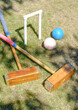 a hoop, 2 malletts and 2 balls from a game of Croquet in a garden
