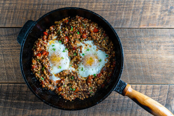 Wall Mural - Boiled buckwheat with fried eggs, red peppers, carrots and onions, closeup, Ukraine. Food background. Healthy food