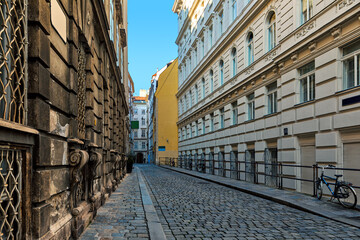 Narrow cobblestone street among historic buildings in Vienna.