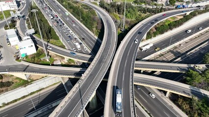 Wall Mural - Aerial drone video of modern multilevel junction with crossing bridges, passing through National road of Athens and Attiki odos motorway