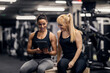 © dusanpetkovic1 - A satisfied sportswoman is sitting next to a female trainer and looking at the progress on a tablet.