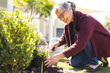 © Wavebreak Media - Happy senior asian woman gardening and replanting flowers