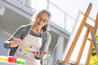 © Wavebreak Media - Happy senior asian woman painting on easel in garden