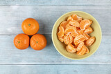 Fototapeta Tulipany - Tangerines in the bowl above dark blue food backgrounds