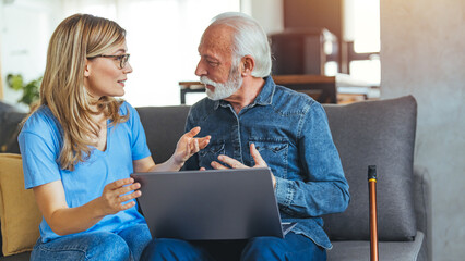 Wall Mural - Female nurse consulting his senior male patient while sitting on sofa during the day. Active senior man using laptop with female carer sitting by on sofa at home.