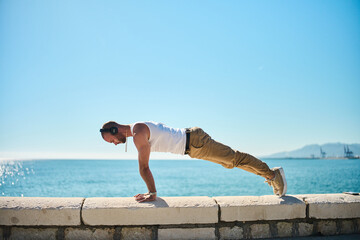 young guy exercising with calisthenics workout in an outdoor gym