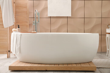 Poster - Interior of bathroom with modern bathtub, folding screen and towels