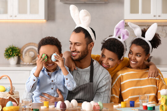 Wall Mural - Happy African American family with Easter eggs at table in kitchen