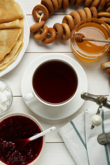 Wall Mural - Metal samovar with cup of tea and treats on white wooden table, flat lay