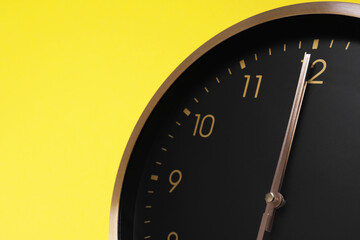 Wall Mural - Closeup view of stylish round clock on yellow background, space for text. Interior element