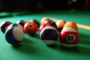 Many colorful billiard balls on green table, closeup