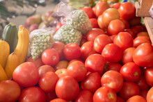 Red Tomatoes, Yellow Zucchini And Green Peas Piled Together In A Marketplace