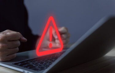Wall Mural - businessman using laptop showing warning triangle and exclamation sign icon caution of dangerous pro