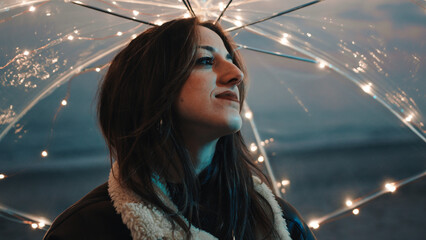 Wall Mural - Glowing umbrella of a girl walking on the beach in the night outdoor