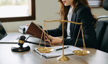 Woman Lawyer In The Office With Brass Scale On Wooden Table. Justice And Law Concept