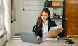 © Nuttapong punna - Attractive young lawyer in office Business woman and lawyers discussing contract papers laptop and tablet with brass scale on  desk in modern office.