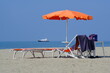 Beach. Umbrellas on the beach. The sea of Viareggio in Versilia. In the background a yacht. 