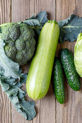 Wall Mural - Green raw vegetables on wooden background. Healthy organic food.