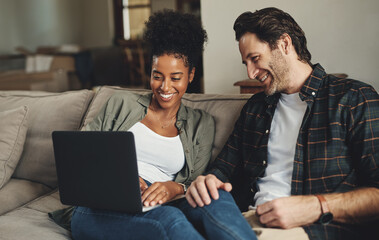 Canvas Print - Were updating all our blogs today. Shot of a happy young couple using a laptop while relaxing on a couch in their living room at home.